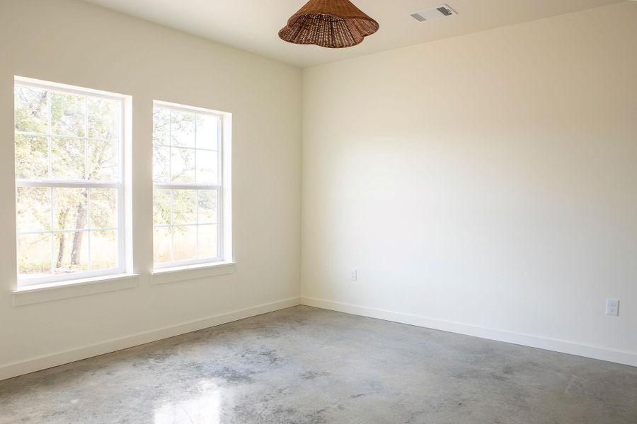 Empty room with concrete floors and baseboards Empty room with concrete floors and baseboards