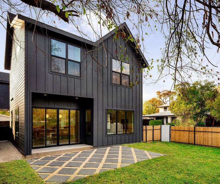 Rear view of property with board and batten siding and a patio area