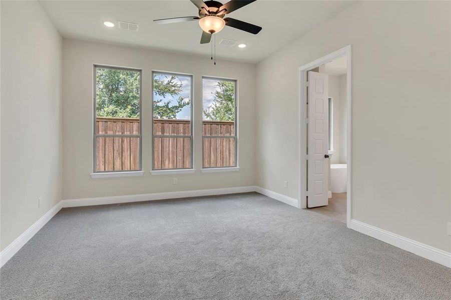 Unfurnished room featuring light colored carpet and ceiling fan