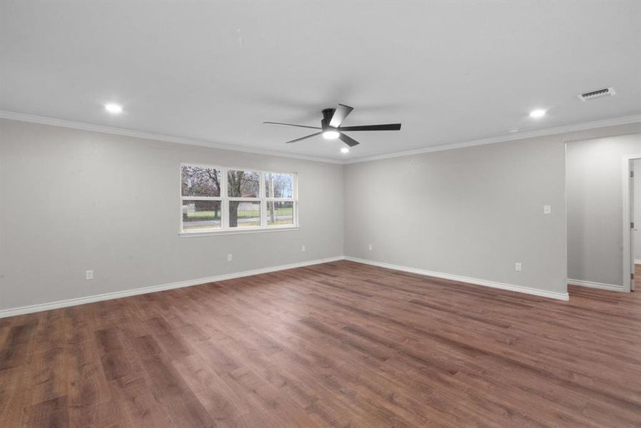Spare room featuring crown molding, ceiling fan, and dark hardwood / wood-style floors Spare room featuring crown molding, ceiling fan, and dark hardwood / wood-style floors