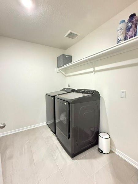 Dedicated laundry room with tile flooring, built-in shelving, and full-size washer and dryer. Dedicated laundry room with tile flooring, built-in shelving, and full-size washer and dryer.