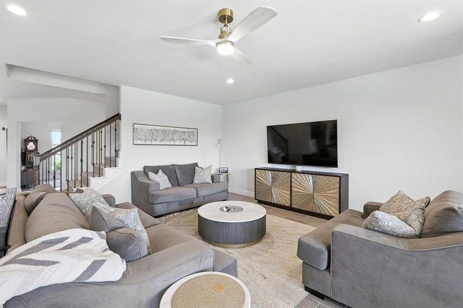 Living room with recessed lighting, stairway, ceiling fan, and wood finished floors