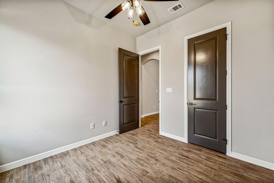 Unfurnished bedroom featuring wood-type flooring and ceiling fan