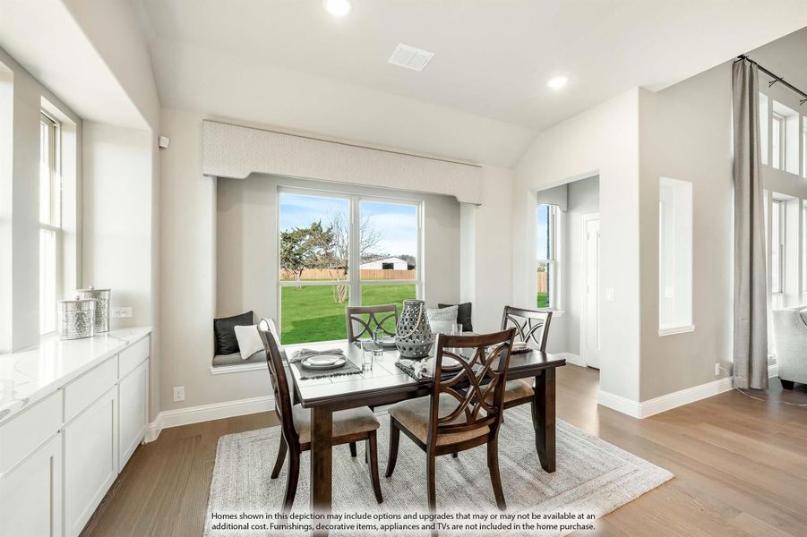 Dining area with dark wood table, four chairs, window seat, and large window overlooking backyard