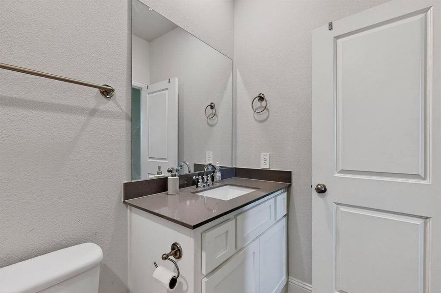 Bathroom with a textured wall and vanity Bathroom with a textured wall and vanity