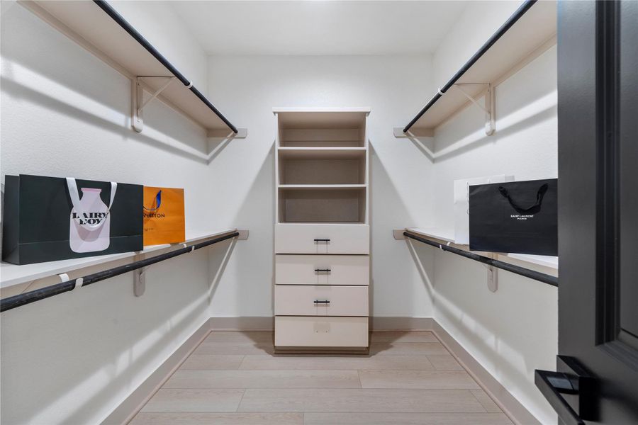Walk-in closet with built-in shelving, drawers, and ample hanging space. Walk-in closet with built-in shelving, drawers, and ample hanging space.