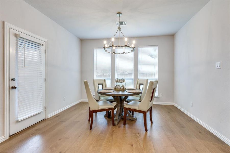 Dining space featuring an inviting chandelier and light hardwood / wood-style flooring