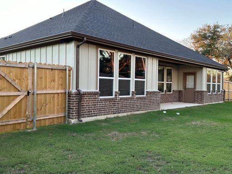 View of side of home with a yard