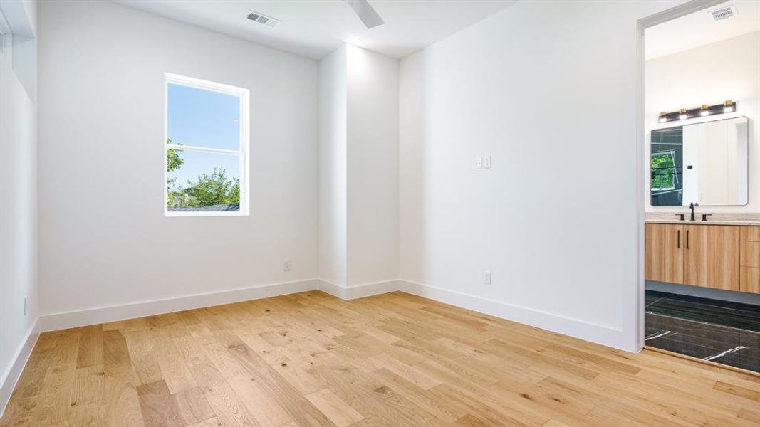 Spare room with a wealth of natural light, sink, ceiling fan, and light hardwood / wood-style floors