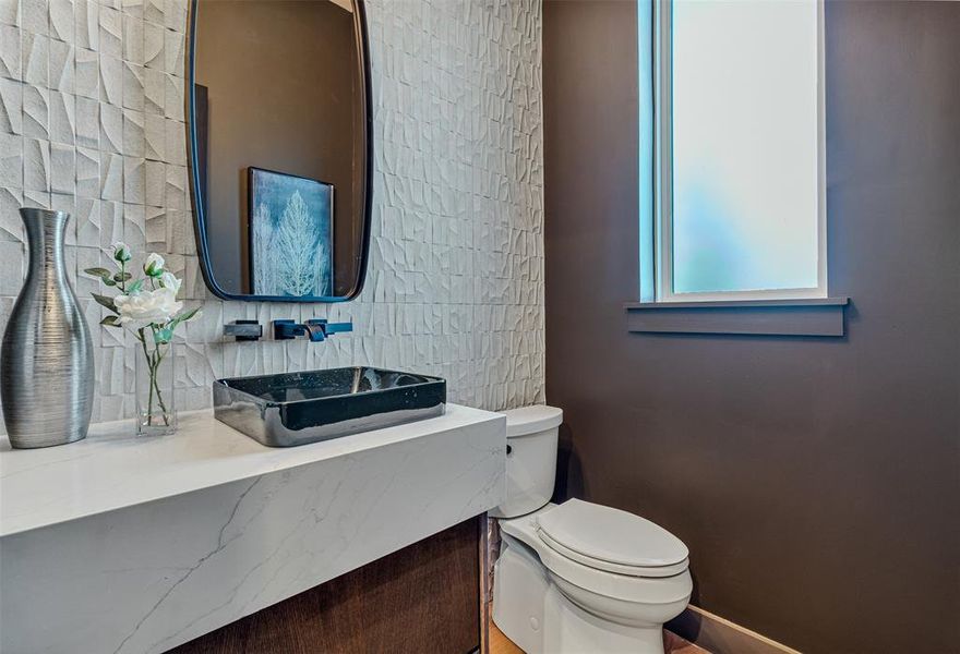 Bathroom featuring vanity and tasteful backsplash