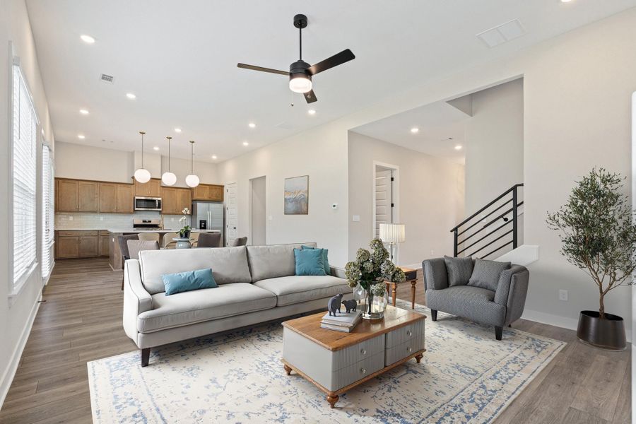Open-concept living area with wood-finish flooring, recessed lighting, and a ceiling fan Open-concept living area with wood-finish flooring, recessed lighting, and a ceiling fan