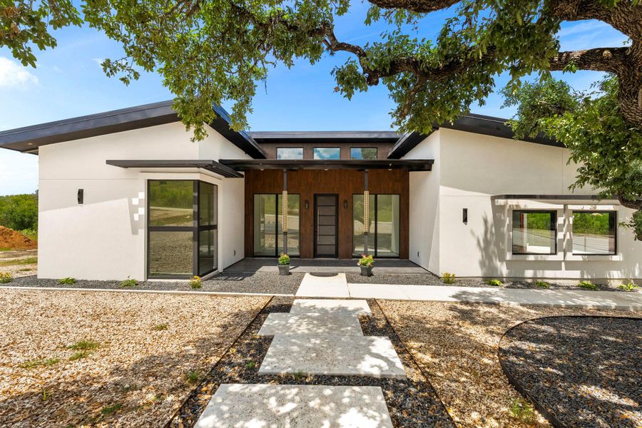 View of front of house featuring covered porch and stucco siding