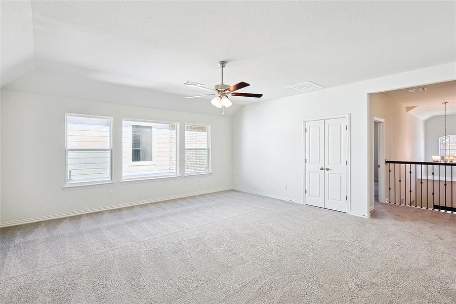 Carpeted empty room with ceiling fan with notable chandelier