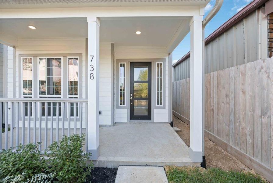 Imagine sipping your morning coffee on this serene front porch, accentuated by neutral paint hues and an elegant 8-foot designer door with side lights.