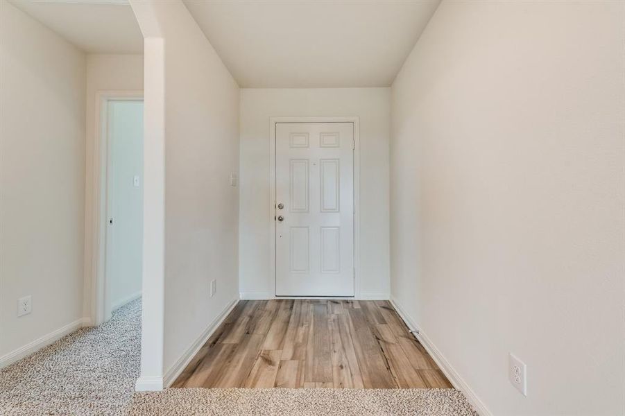 Doorway featuring light carpet