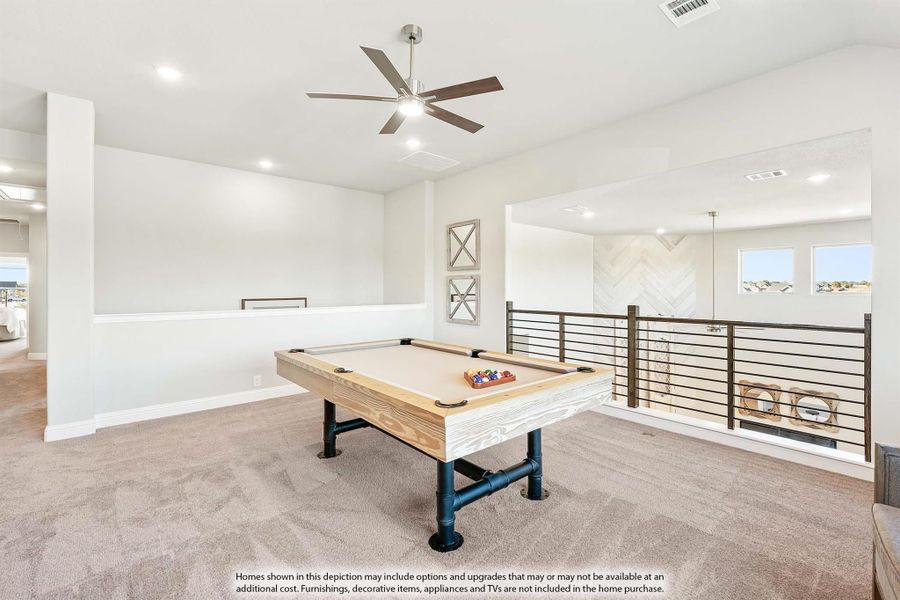Upstairs game room with pool table, ceiling fan, carpet flooring, and open metal railing overlooking lower level