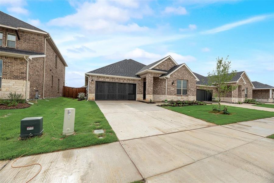 Front exterior of a new home in Spiritas Ranch, Little Elm, TX, highlighting curb appeal (Image 27). Front exterior of a new home in Spiritas Ranch, Little Elm, TX, highlighting curb appeal (Image 27).