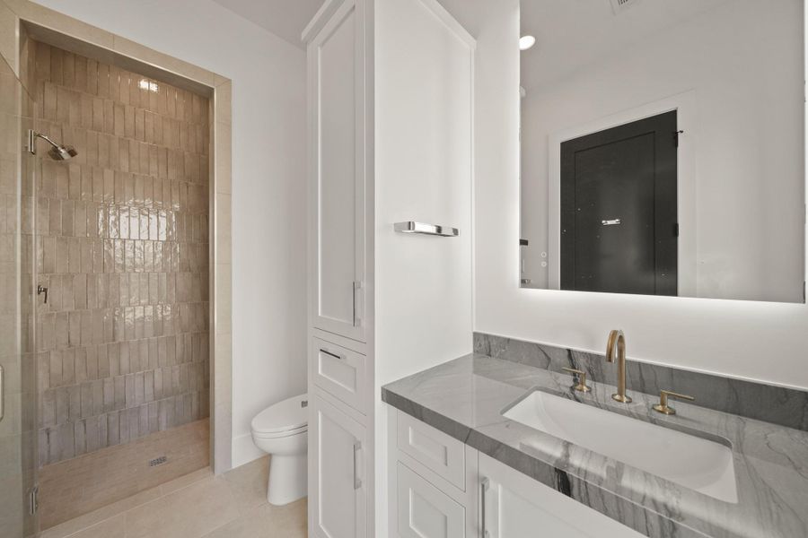 One of the secondary bedroom bathrooms. Custom cabinetry built in-to every bedroom closet and bathroom.
