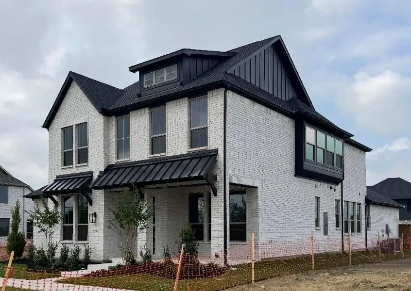Front exterior of a new home in The Grove Frisco, Frisco, TX, highlighting curb appeal (Image 2). Front exterior of a new home in The Grove Frisco, Frisco, TX, highlighting curb appeal (Image 2).