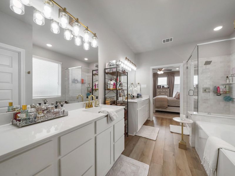 Dual vanities provide ample space for daily routines, complemented by upgraded fixtures and a clean, modern finish.