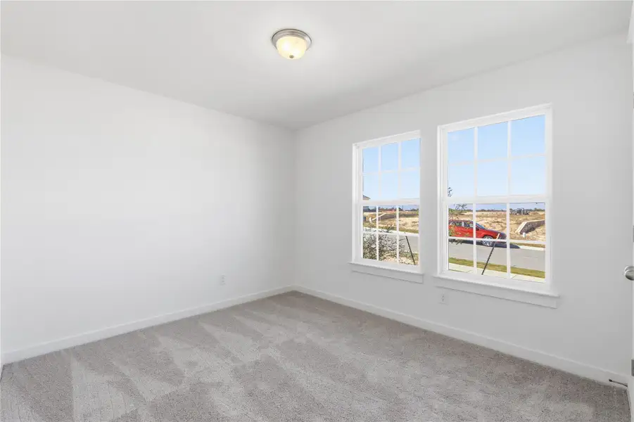 Carpeted spare room with baseboards