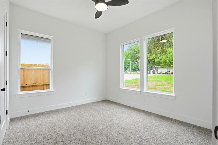 Carpeted room with a ceiling fan