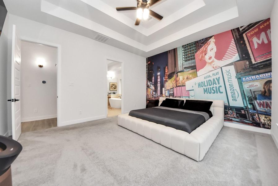 Large primary bedroom with elevated ceilings and convenient ensuite access.