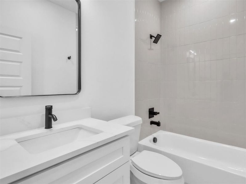Full bath featuring shower / bathtub combination, vanity, and toilet Full bath featuring shower / bathtub combination, vanity, and toilet