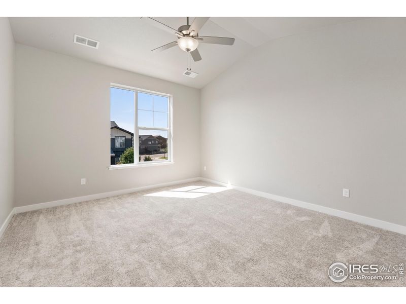 Primary bedroom w/ vaulted ceiling and ceiling fan!