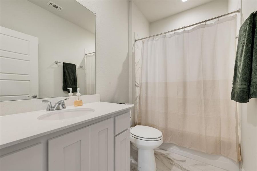Full bath with vanity, light marble finish flooring, and shower / bathtub combination with curtain Full bath with vanity, light marble finish flooring, and shower / bathtub combination with curtain
