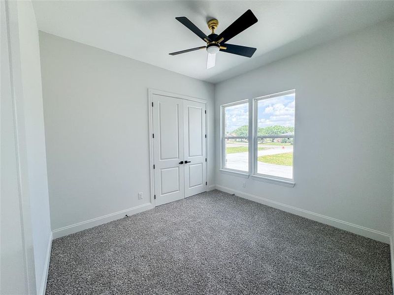Unfurnished bedroom with baseboards, carpet, ceiling fan, and a closet Unfurnished bedroom with baseboards, carpet, ceiling fan, and a closet