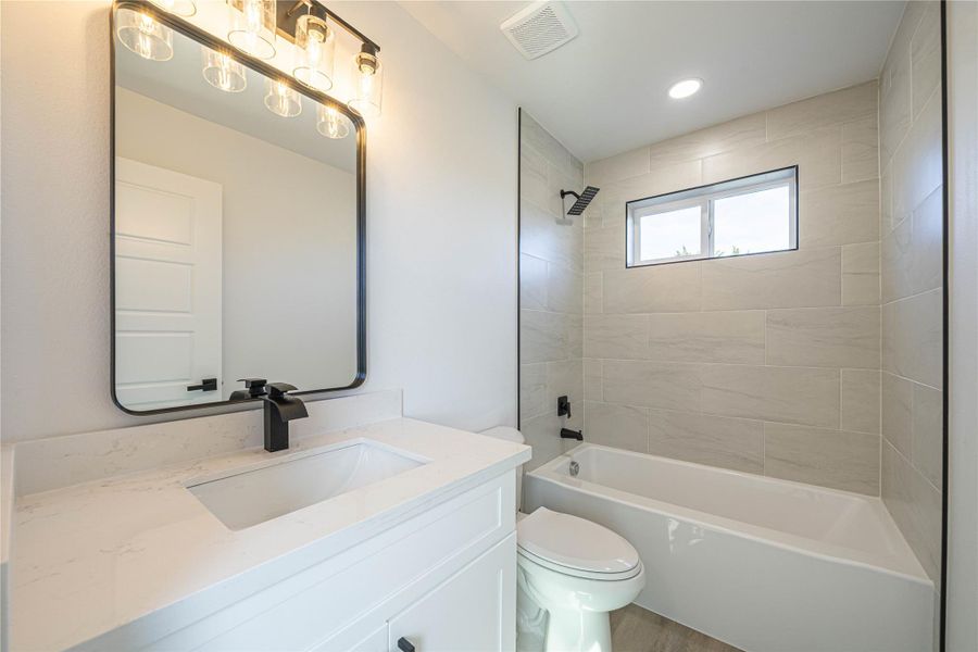 Bathroom featuring vanity and washtub / shower combination
