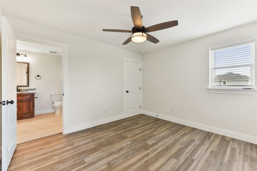 Bedroom 2 with baseboards, ensuite bath, visible vents, and light wood-style floors Bedroom 2 with baseboards, ensuite bath, visible vents, and light wood-style floors