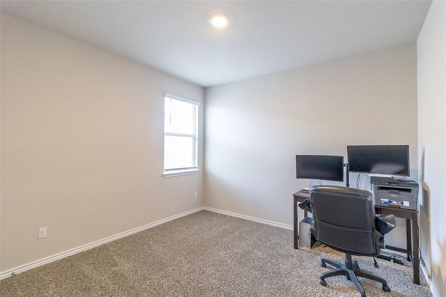 A well-lit study with carpeted flooring offers a dedicated space for productivity. A well-lit study with carpeted flooring offers a dedicated space for productivity.