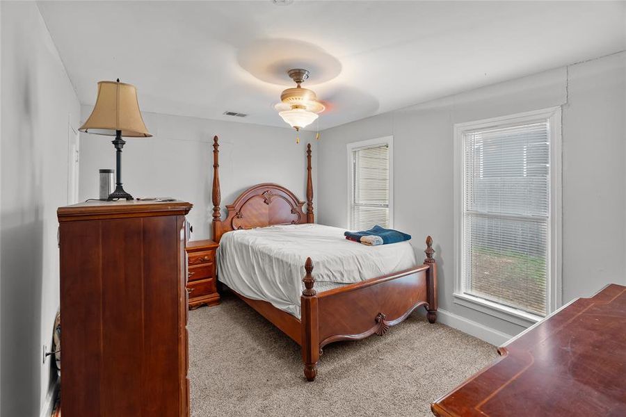 Carpeted bedroom featuring ceiling fan