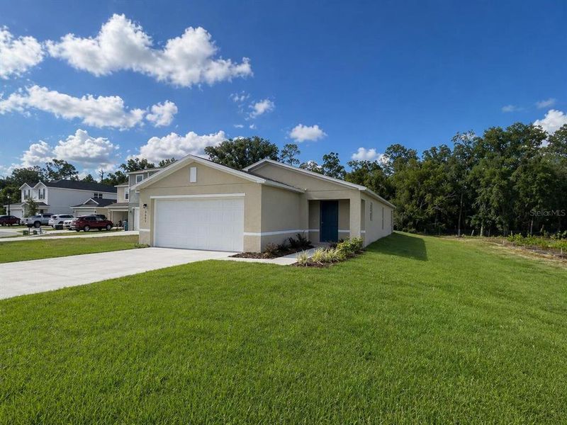 Front exterior of a new home in Eagle Hammock, Eagle Lake, FL, highlighting curb appeal (Image 21).