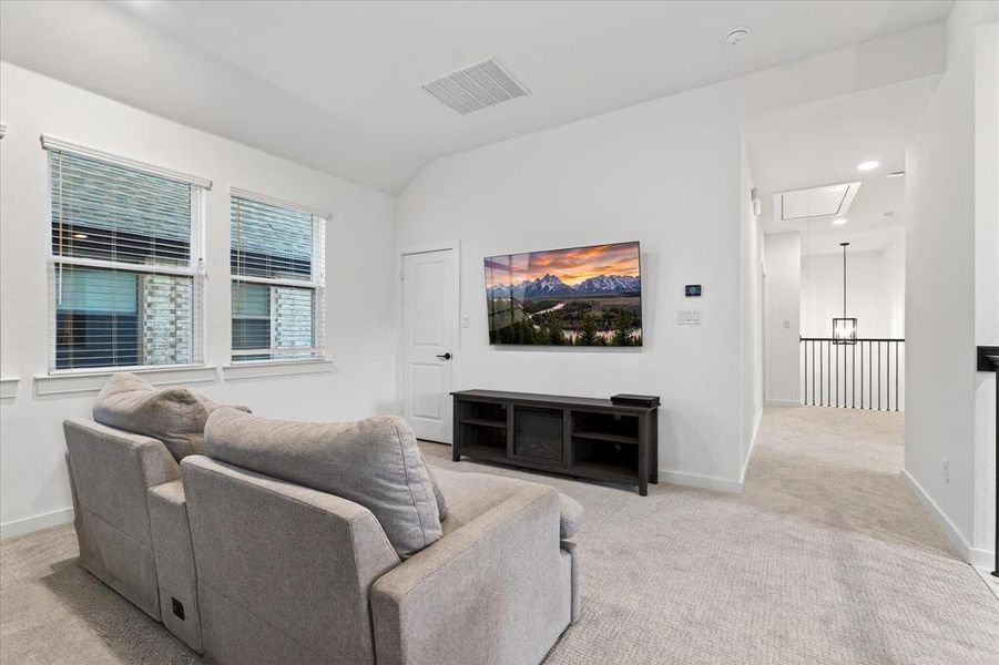 Living room with attic access, light carpet, lofted ceiling, and recessed lighting Living room with attic access, light carpet, lofted ceiling, and recessed lighting