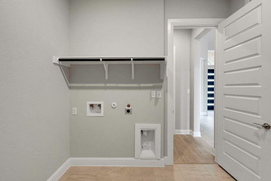 Laundry area featuring gas dryer hookup, electric dryer hookup, washer hookup, and light tile patterned floors Laundry area featuring gas dryer hookup, electric dryer hookup, washer hookup, and light tile patterned floors
