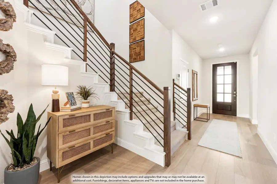 Entryway with staircase featuring wood and metal railing, light hardwood floors, and front door with glass panels Entryway with staircase featuring wood and metal railing, light hardwood floors, and front door with glass panels