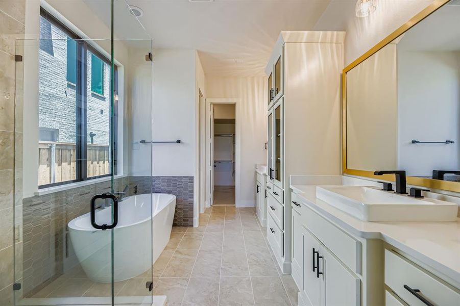 Full bathroom featuring vanity, a spacious closet, a shower stall, a soaking tub, and tile patterned flooring