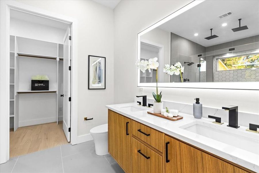 Bathroom with toilet, wood-type flooring, and double vanity