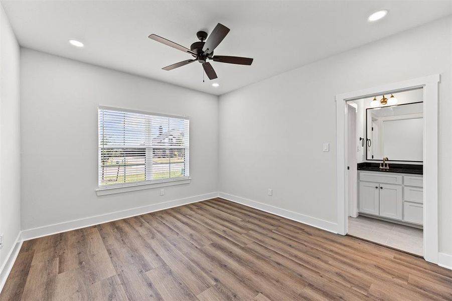Unfurnished bedroom with light wood-style floors, recessed lighting, ceiling fan, and ensuite bath Unfurnished bedroom with light wood-style floors, recessed lighting, ceiling fan, and ensuite bath