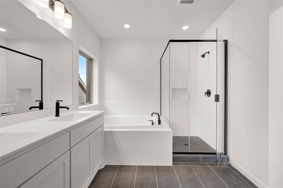 Full bathroom with a bath, double vanity, a shower stall, and recessed lighting