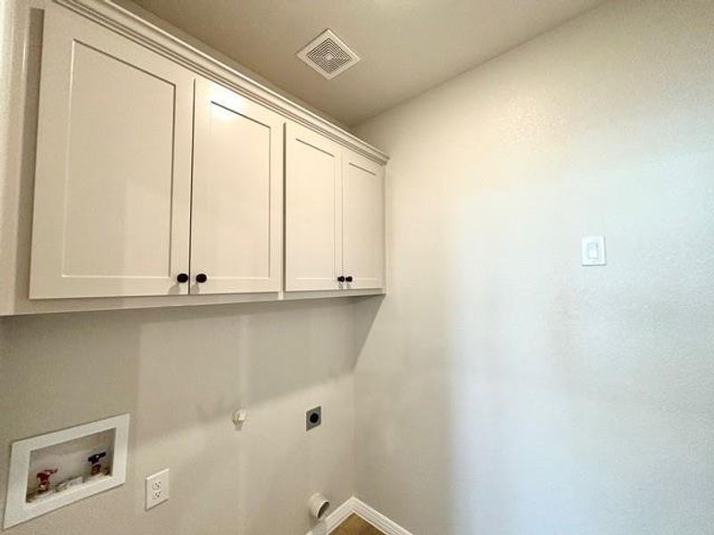 Laundry area with hookup for a gas dryer, hookup for a washing machine, cabinets, and hookup for an electric dryer