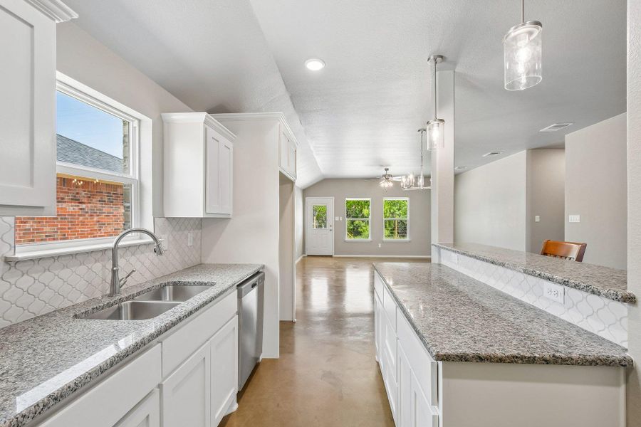 A well-appointed kitchen features ample counter space and modern fixtures, flowing into a bright living area. A well-appointed kitchen features ample counter space and modern fixtures, flowing into a bright living area.