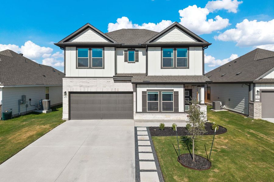 A spacious driveway and neat walkway lead to a modern two-story home with neutral siding. A spacious driveway and neat walkway lead to a modern two-story home with neutral siding.