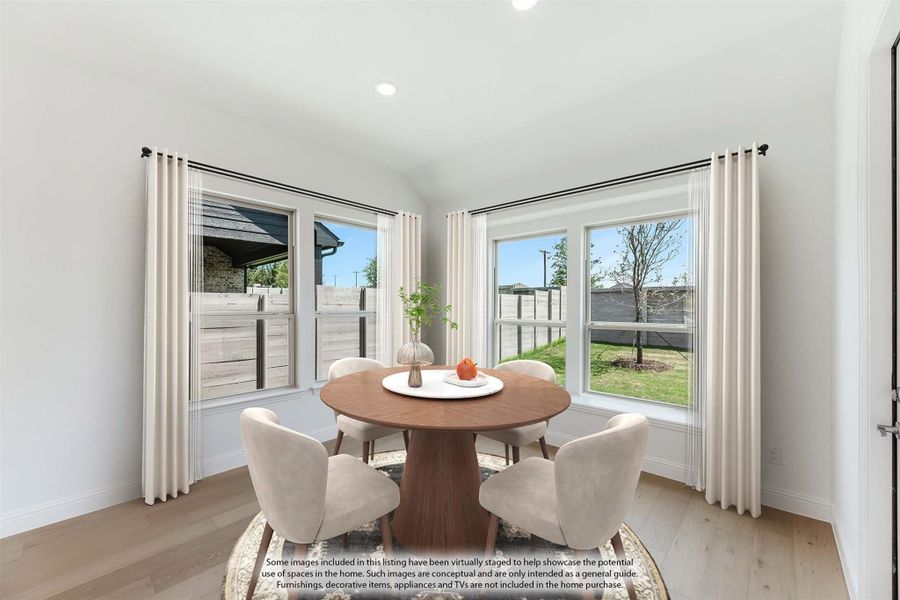 Dining area with round wood table, four chairs, hardwood floors, and large windows with white curtains
