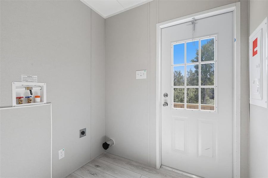 Laundry room featuring electric panel, washer hookup, light wood-style floors, and hookup for an electric dryer Laundry room featuring electric panel, washer hookup, light wood-style floors, and hookup for an electric dryer