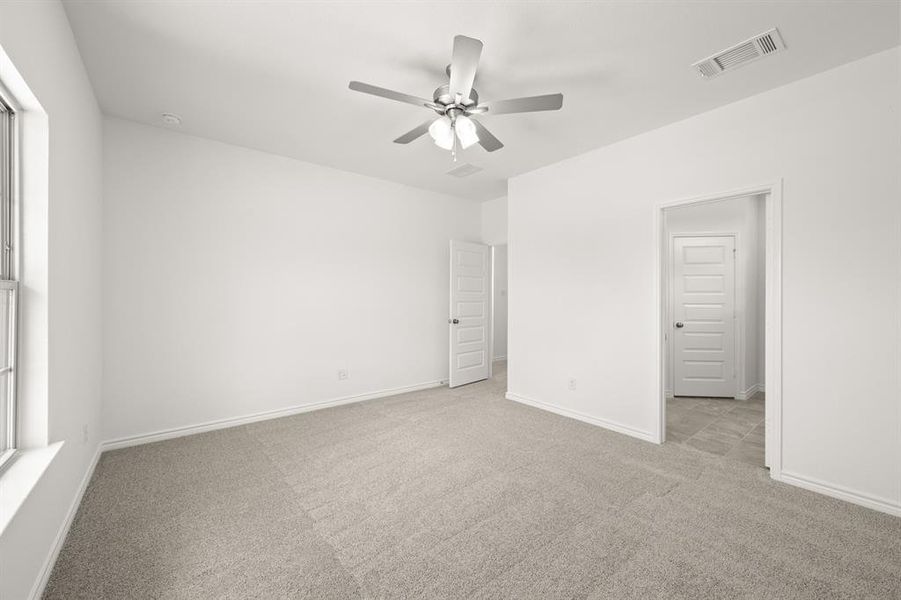 Carpeted empty room featuring ceiling fan