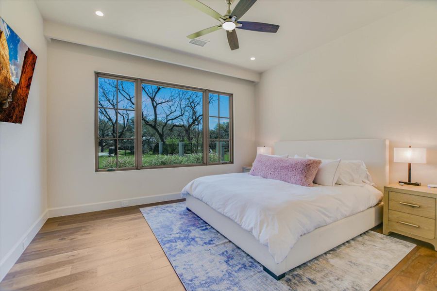 Bedroom with light wood-style floors, a ceiling fan, and recessed lighting